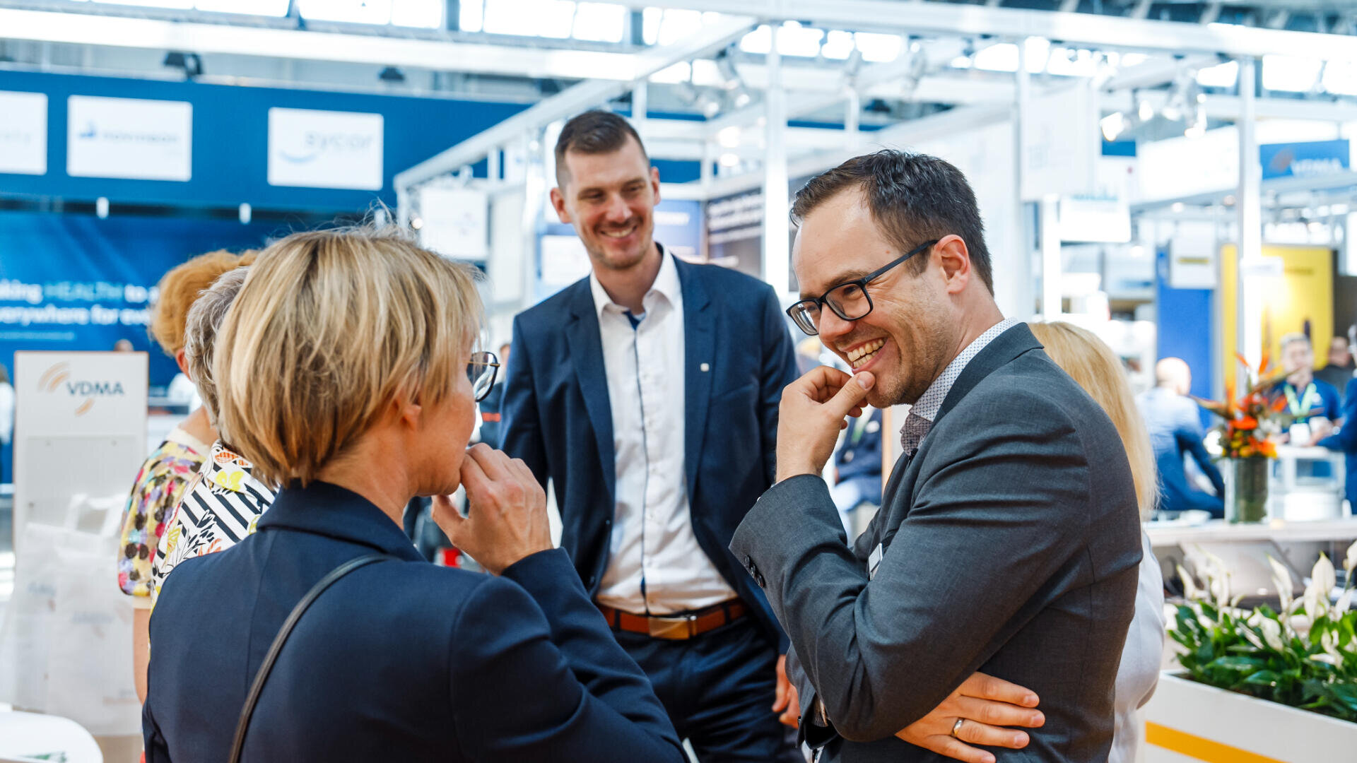 Smiling delegates in conversation on an exhibition floor
