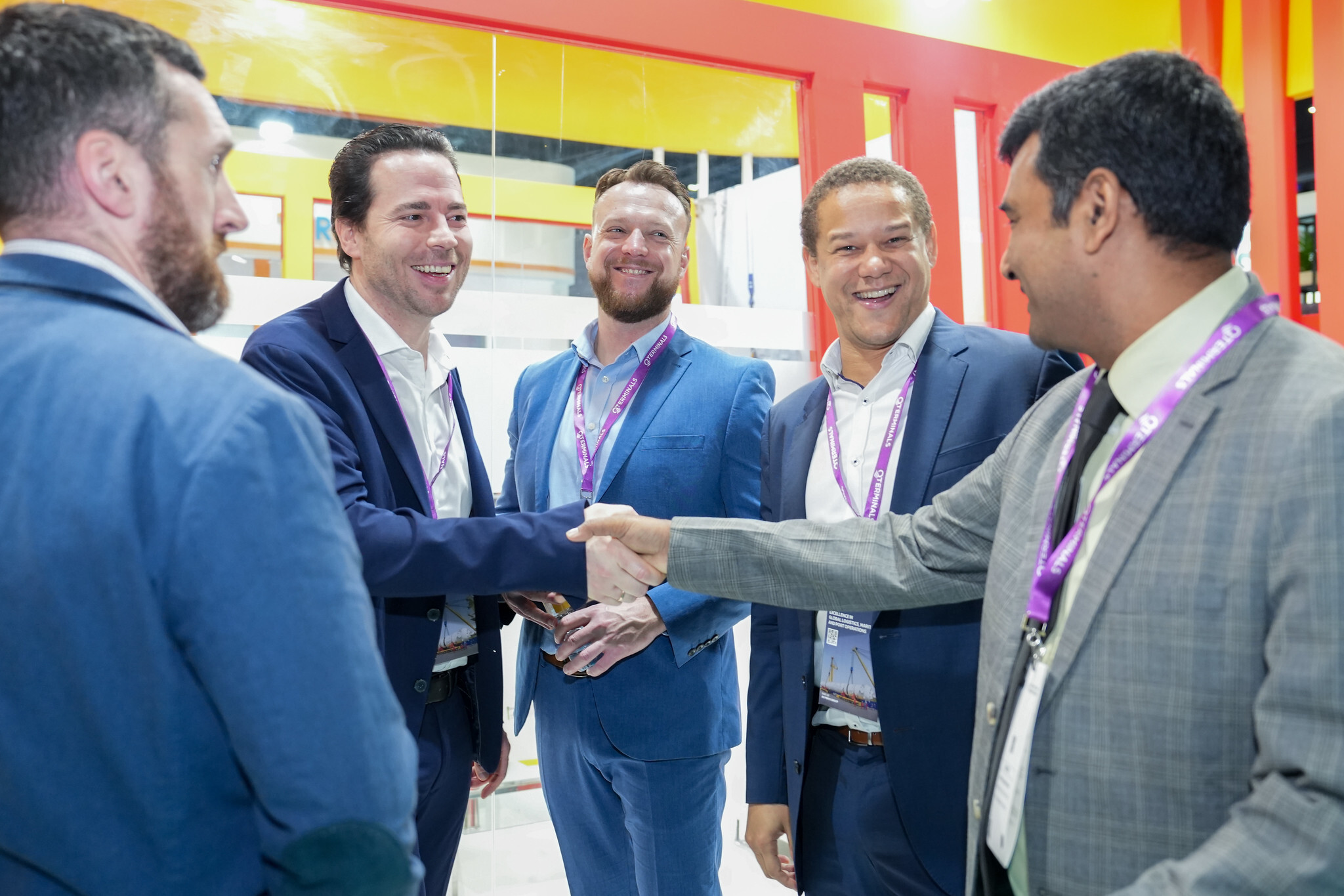 Smiling exhibitors and visitors greeting each other at a trade exhibition